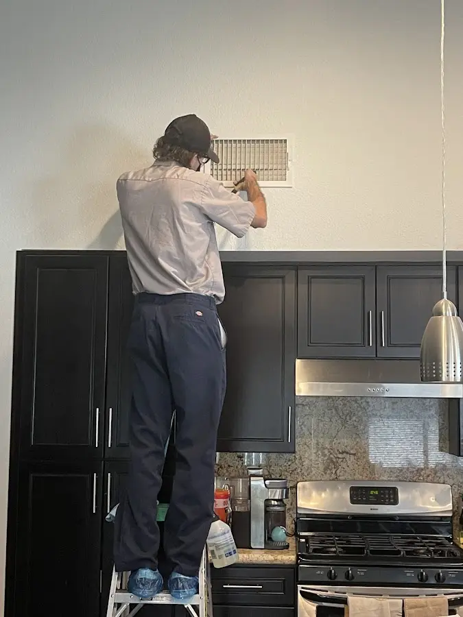 Technician inspecting an air vent during HVAC service in Salida del Sol Estates